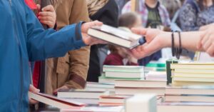 A person buying a book at the spring used book sale.